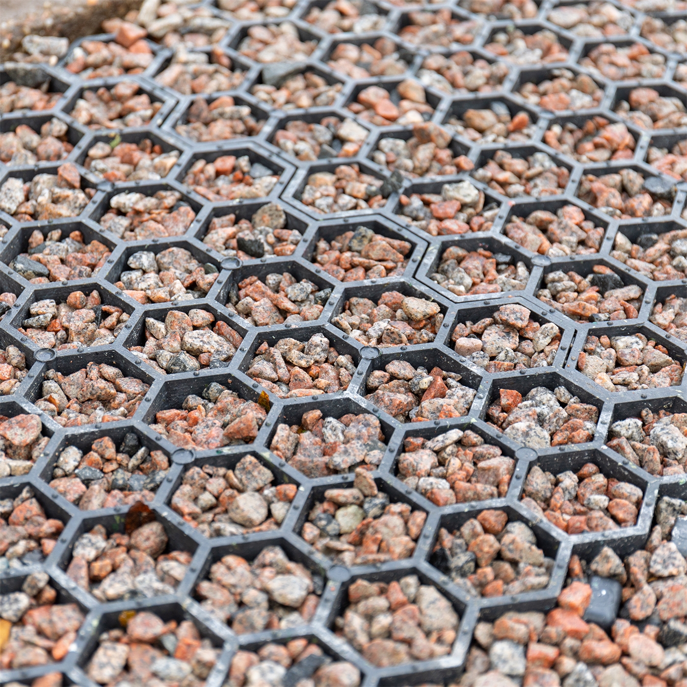 Doppelklicken zum vergrößern Nahaufnahme kleiner Steine, die durch die VOSS.farming Paddockplatte (Rasengitter, Paddockgitter, 50 x 40 x 4 cm) an ihrem Platz gehalten werden.