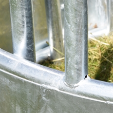 Eine Nahaufnahme des verzinkten Metallpalisadenzauns eines VOSS.farming Rundballenraufe-Spar-Sets, bestehend aus einer Rundraufe mit 8 Fressplätzen, einem Palisadenfressgitter und einem Netz.