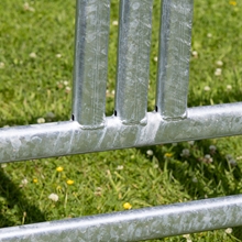 Nahaufnahme des VOSS.farming Weidepanel mit Sicherheitsfressgitter (3,00m x 1,70m) von VOSS.farming, ein verzinktes Metallzaunpanel, mit grünem Gras und kleinen Blumen im Hintergrund.