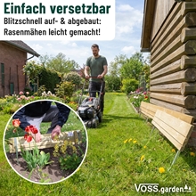Ein Mann mäht den Rasen in der Nähe einer VOSS.garden Steckzaun 75x18cm Holzumrandung mit Metallpfosten; der Einsatz zeigt die Umrandung mit Blumen.