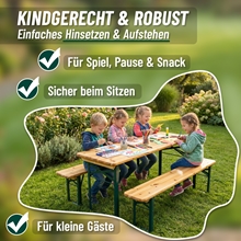 Vier kleine Kinder sitzen an der VOSS.garden Bierzeltgarnitur 110cm - einem klappbaren Holztisch mit zwei Bänken - und malen und spielen draußen im Garten.